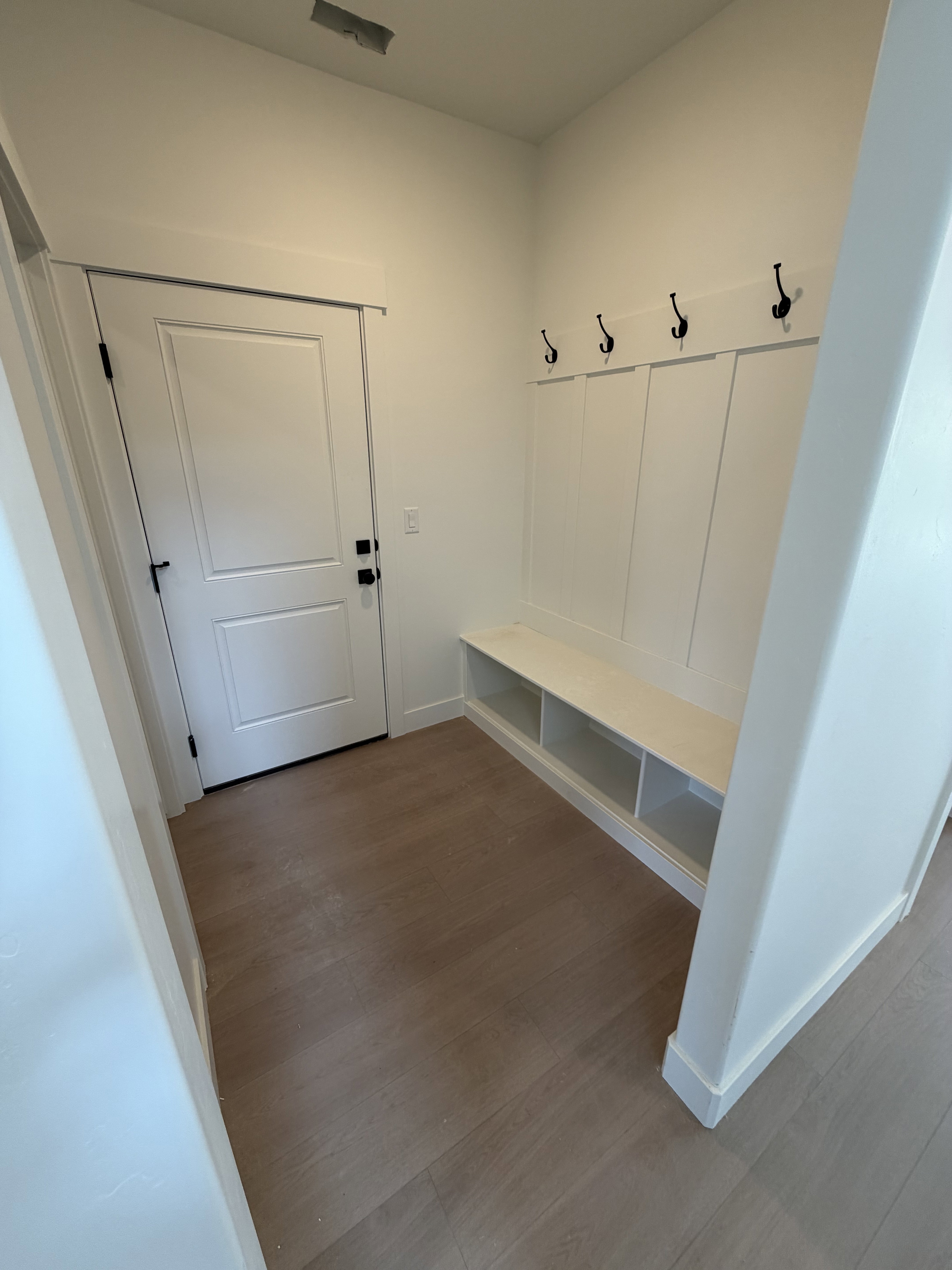 Entryway featuring light wood-finish flooring and a built-in bench with integrated storage cubbies