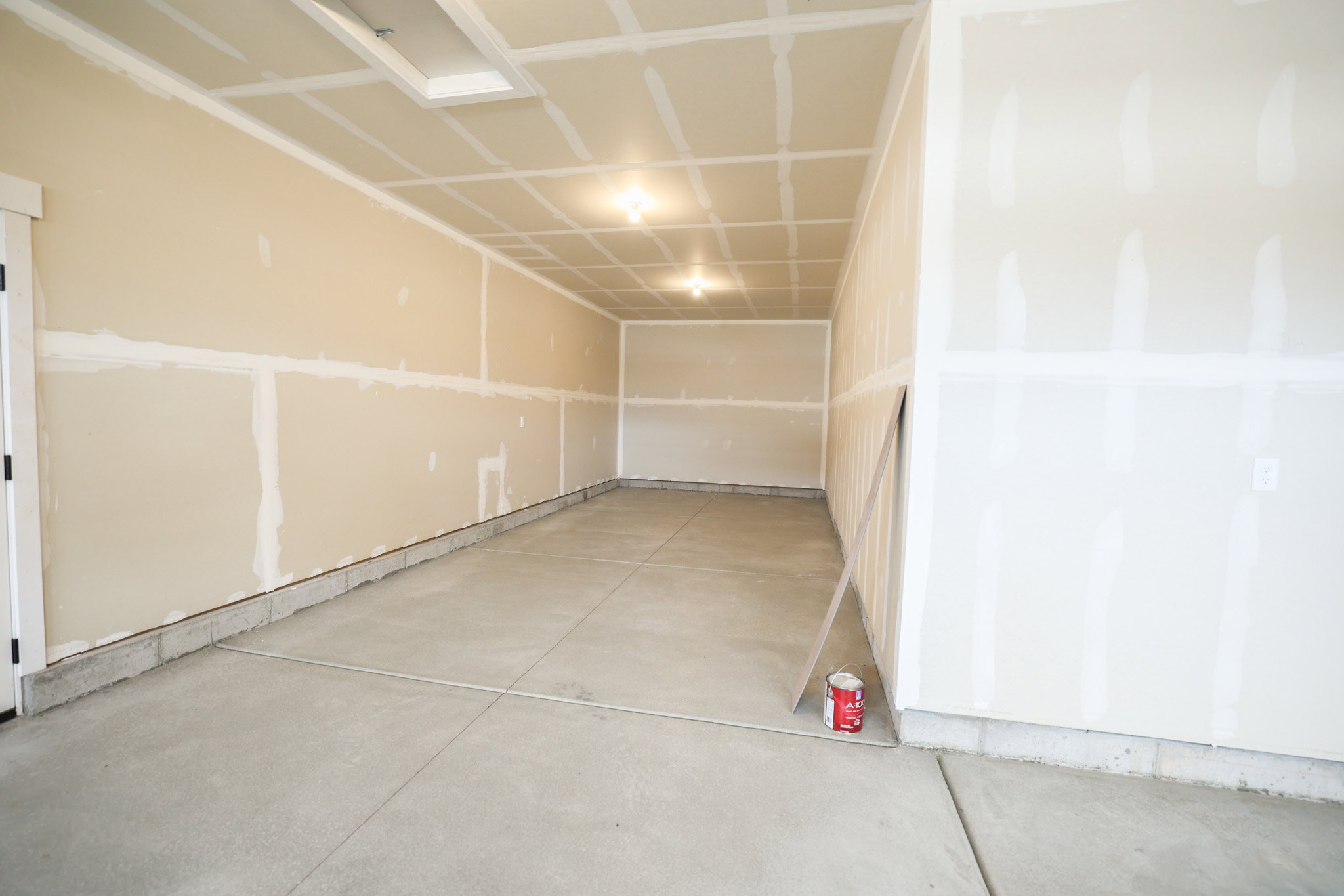 Unfinished interior space featuring drywall, concrete flooring, and an overhead light fixture