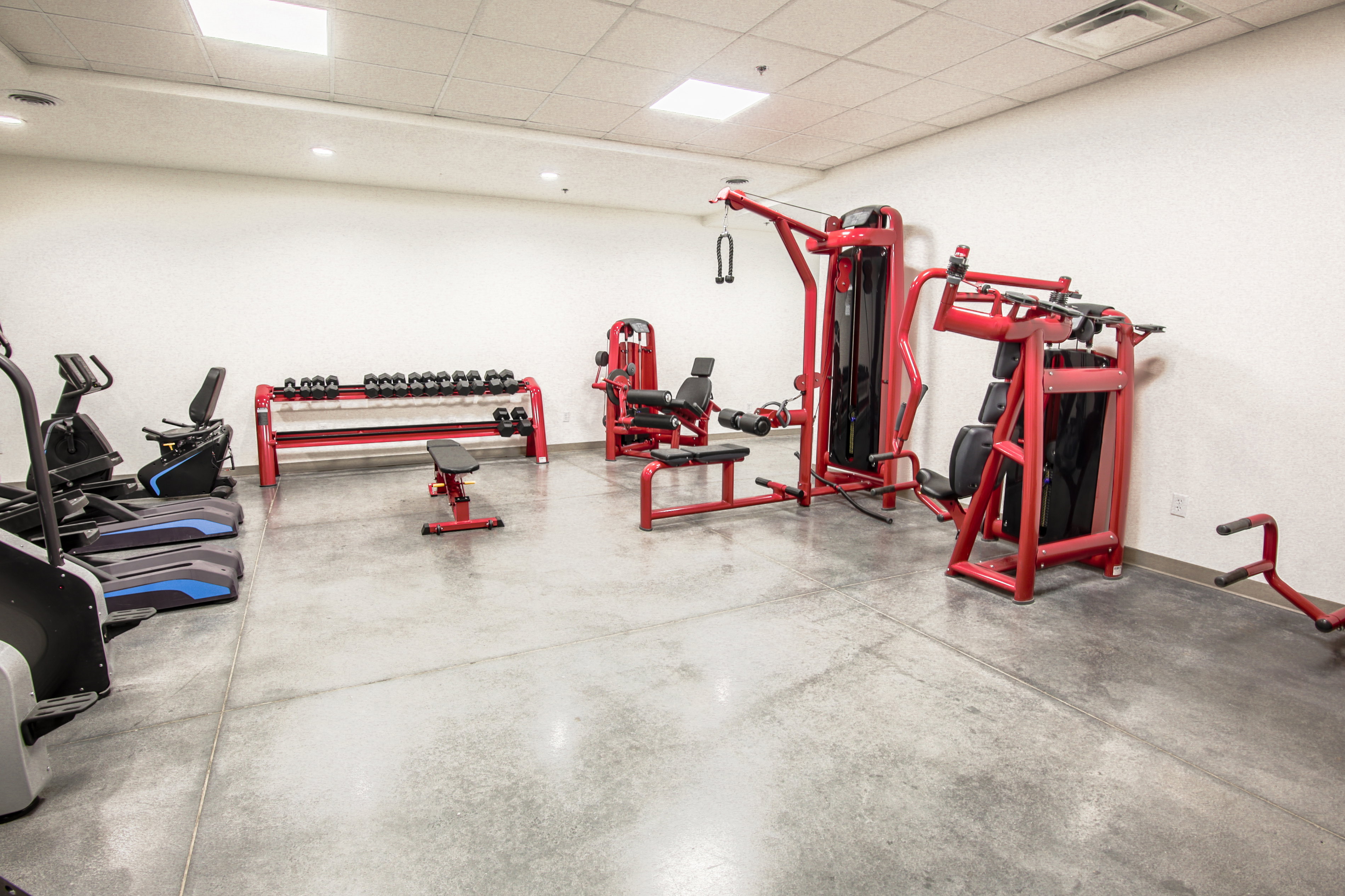 Fitness center featuring concrete flooring and white walls