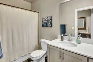 Bathroom with a single vanity featuring a built-in sink, light countertop, and under-sink cabinetry