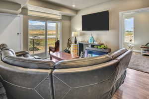 Living area featuring sliding glass doors with transom windows, wood-finish flooring, and a built-in media console with a fireplace