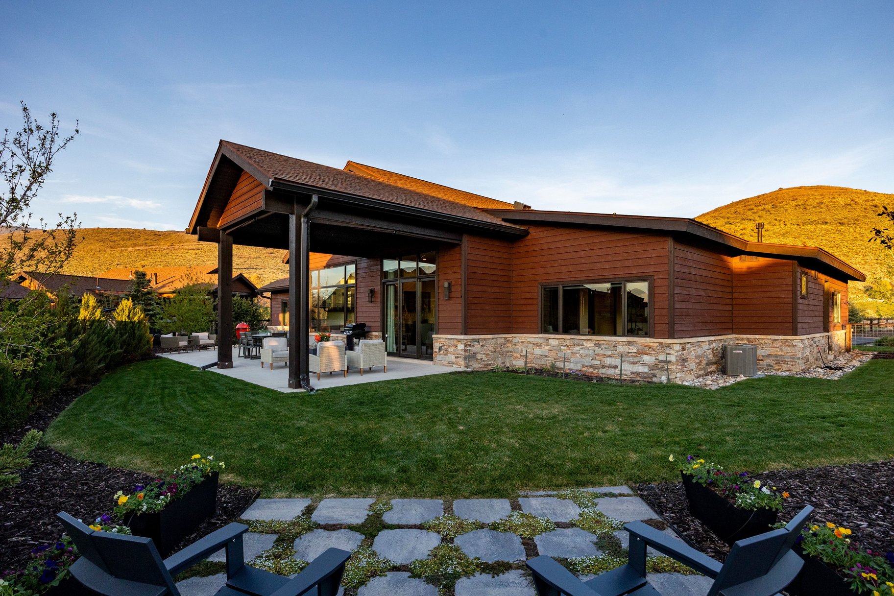 Modern architectural design with a covered patio, extensive glass doors, and durable siding