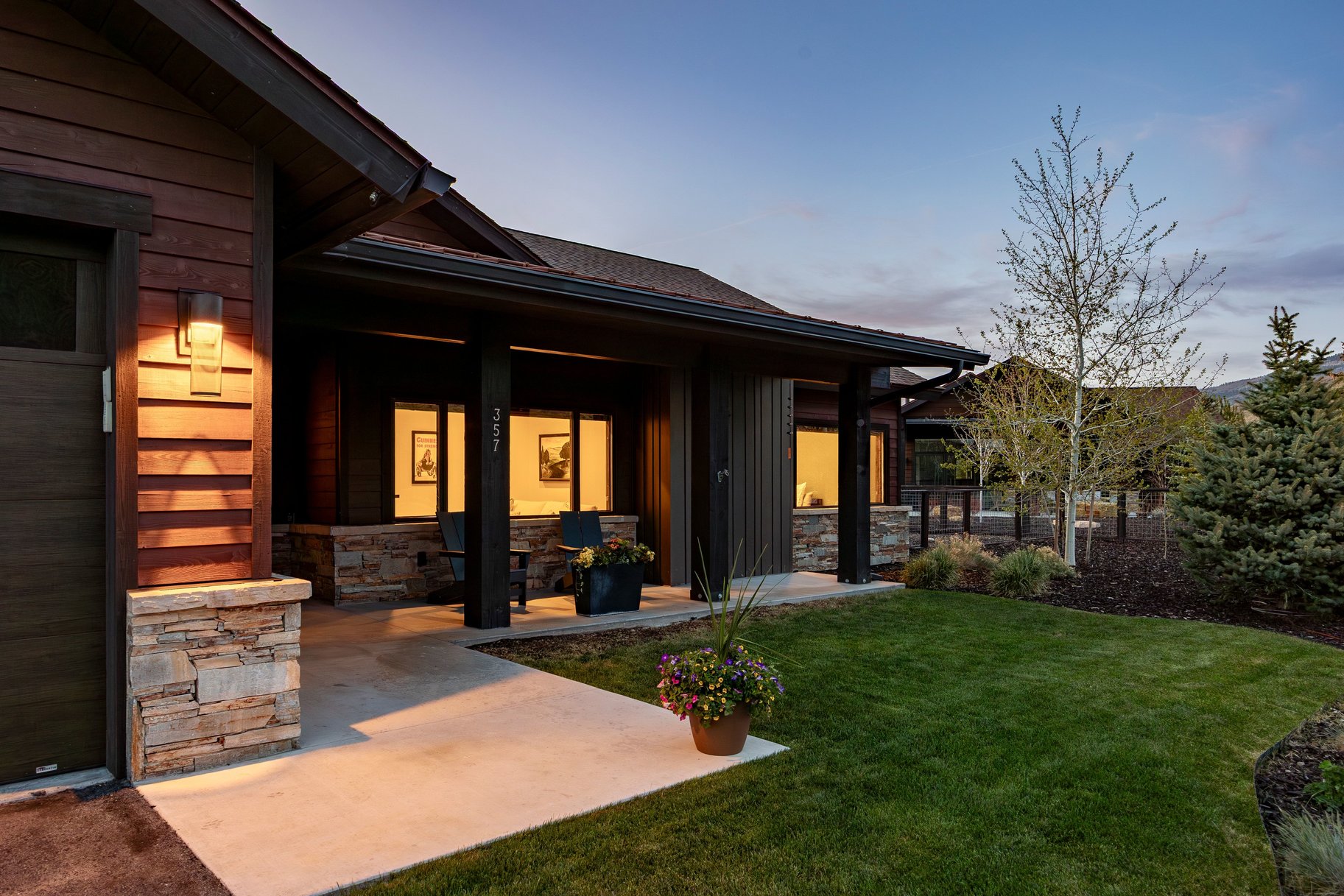 Modern exterior featuring dark wood siding and stacked stone accents