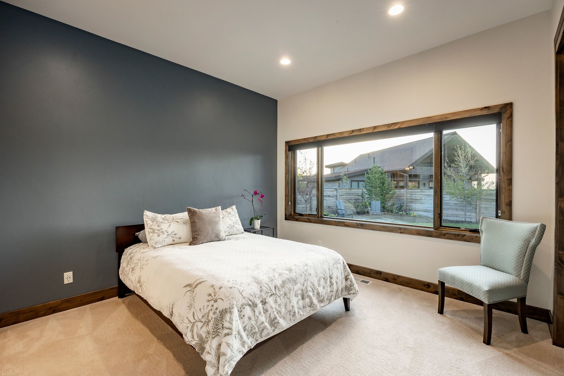 Room featuring a substantial window with wood-finish trim, a contrasting accent wall, recessed lighting, and carpet flooring