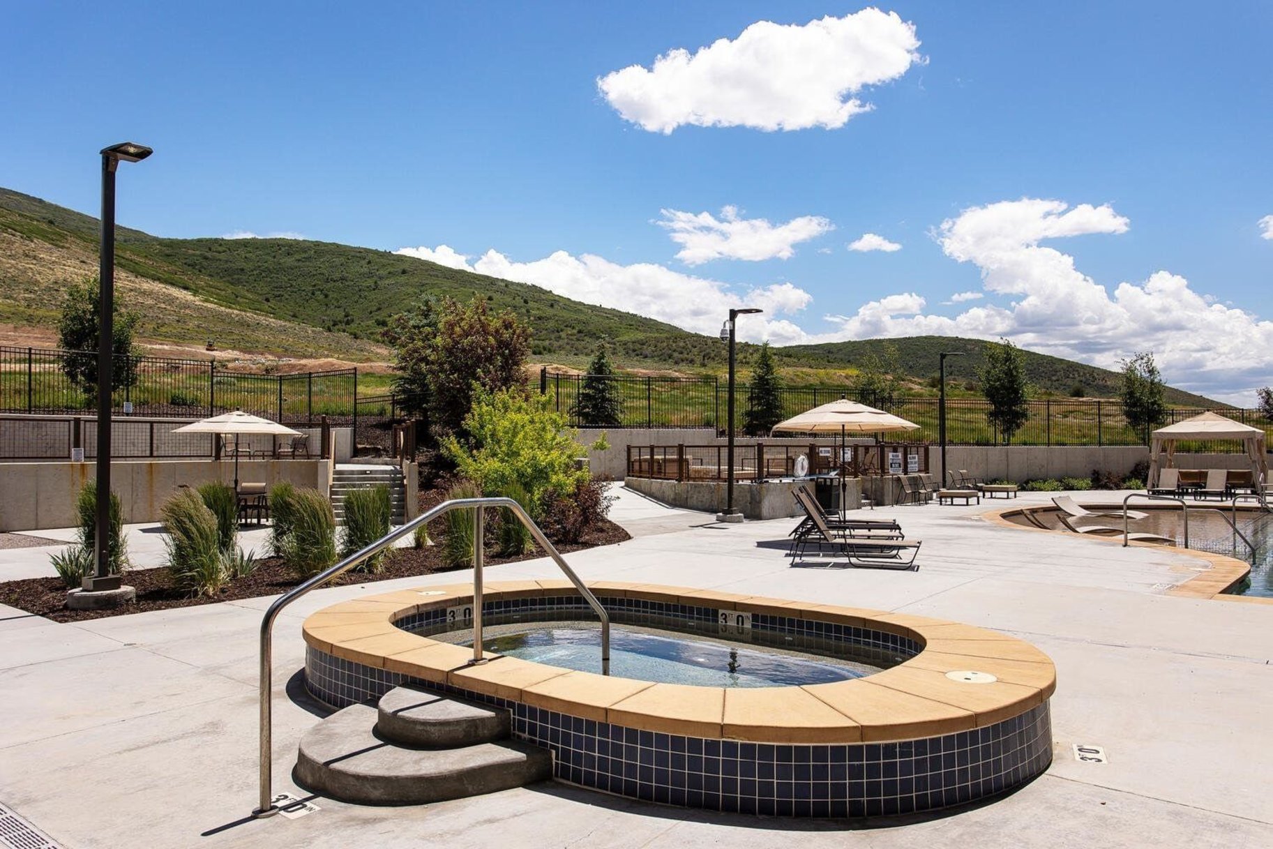 Outdoor spa with tiled exterior and a concrete surround