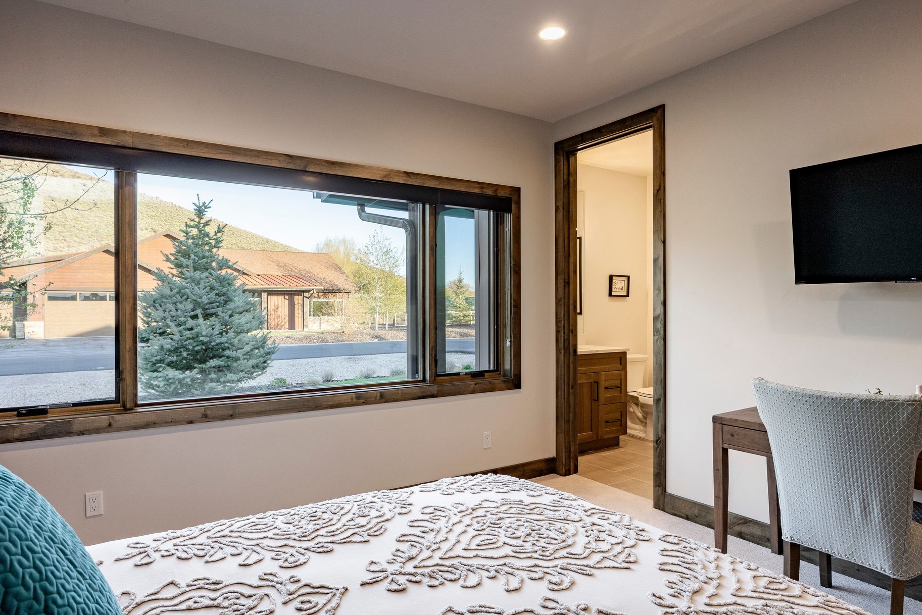 Expansive window with wood trim framing the exterior landscape