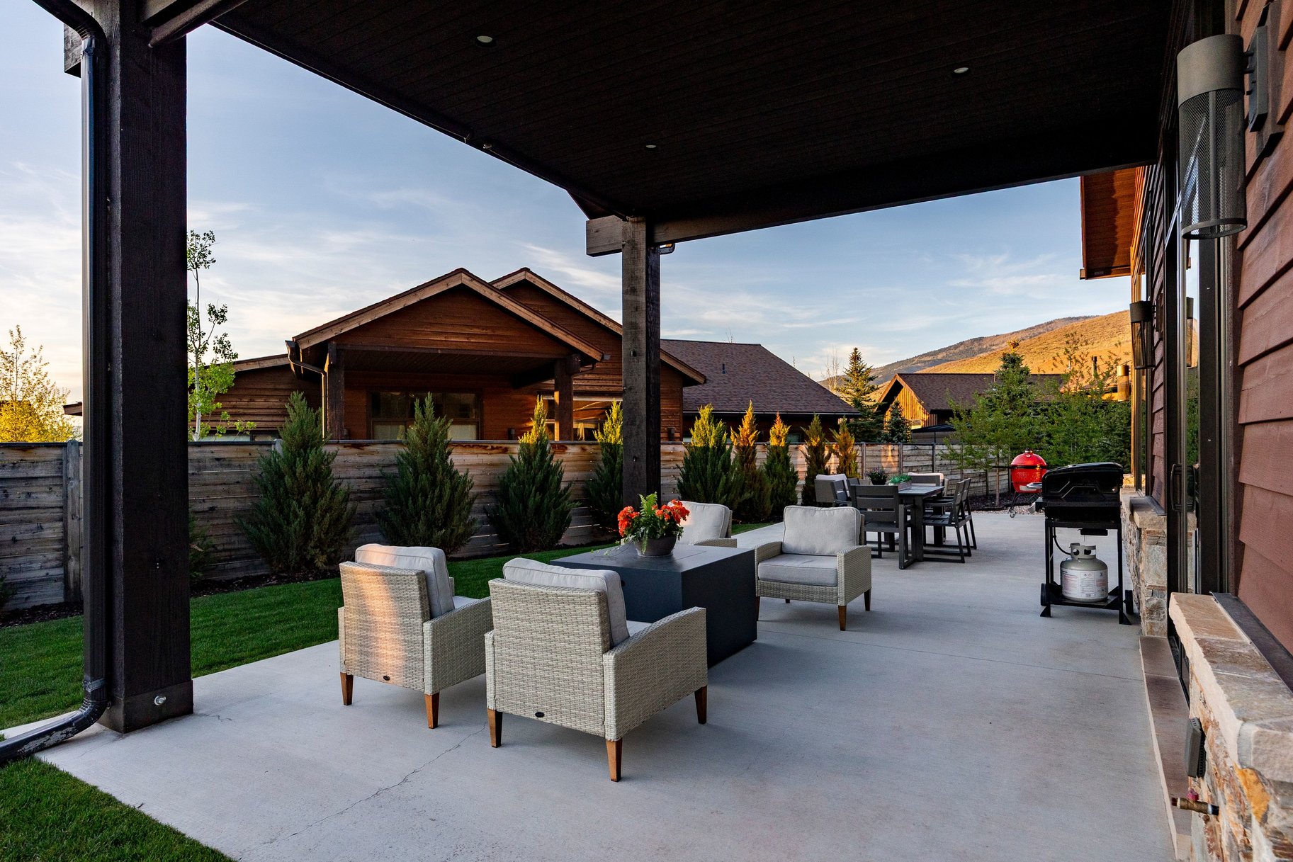 Expansive covered patio featuring a concrete surface and dark overhead structural beams