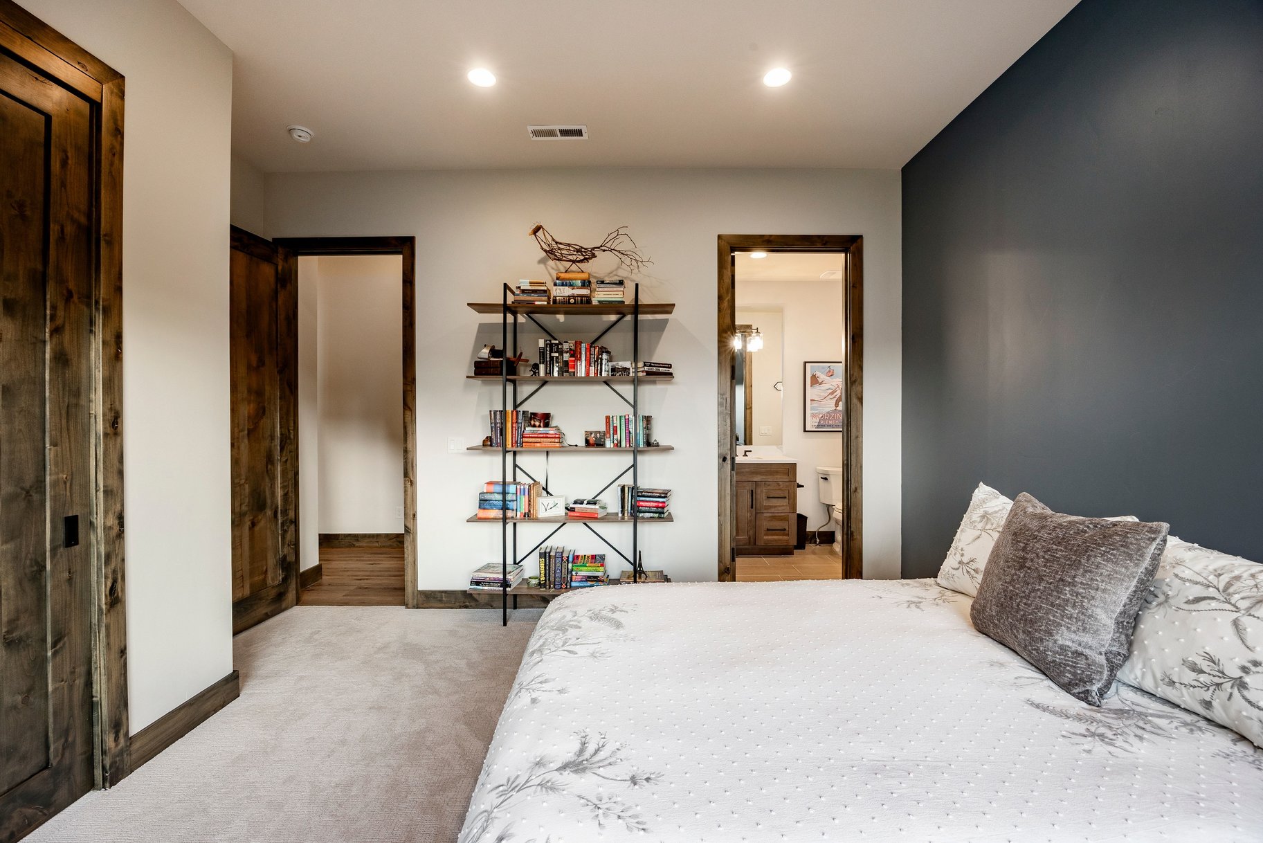 Bedroom featuring light carpeting, a dark accent wall, and recessed lighting