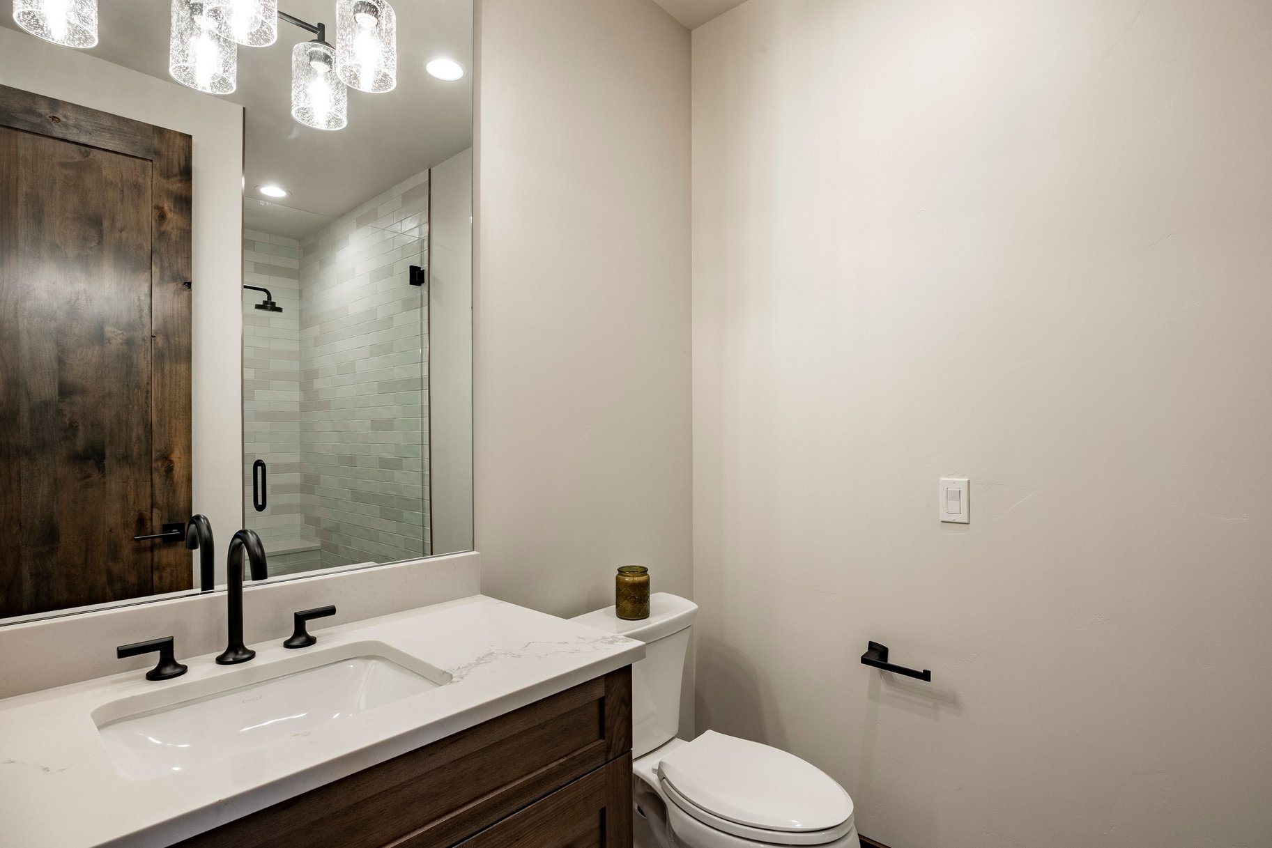 Bathroom vanity featuring a rectangular undermount sink, a white countertop, and dark wood-finish cabinetry