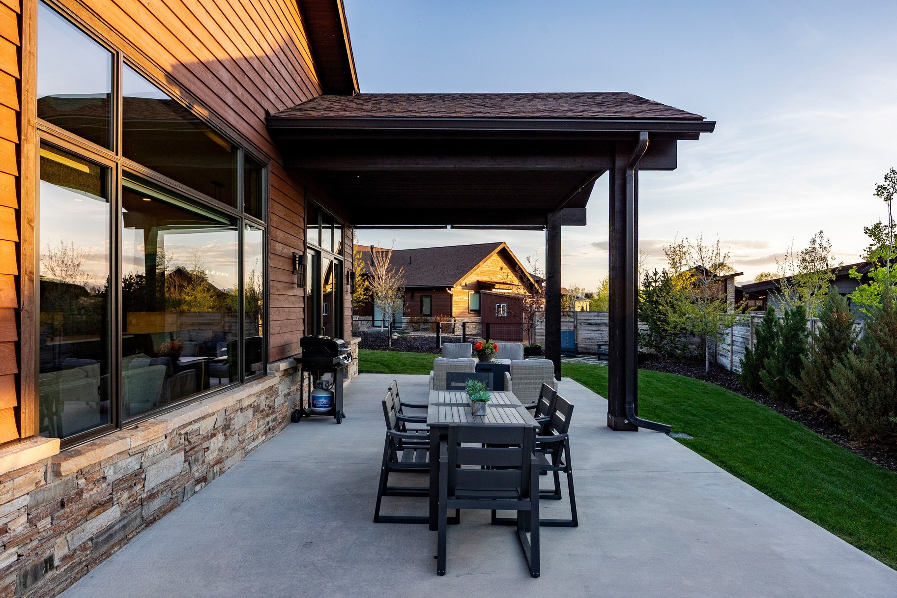 Expansive covered patio featuring a concrete surface and dark-stained structural beams