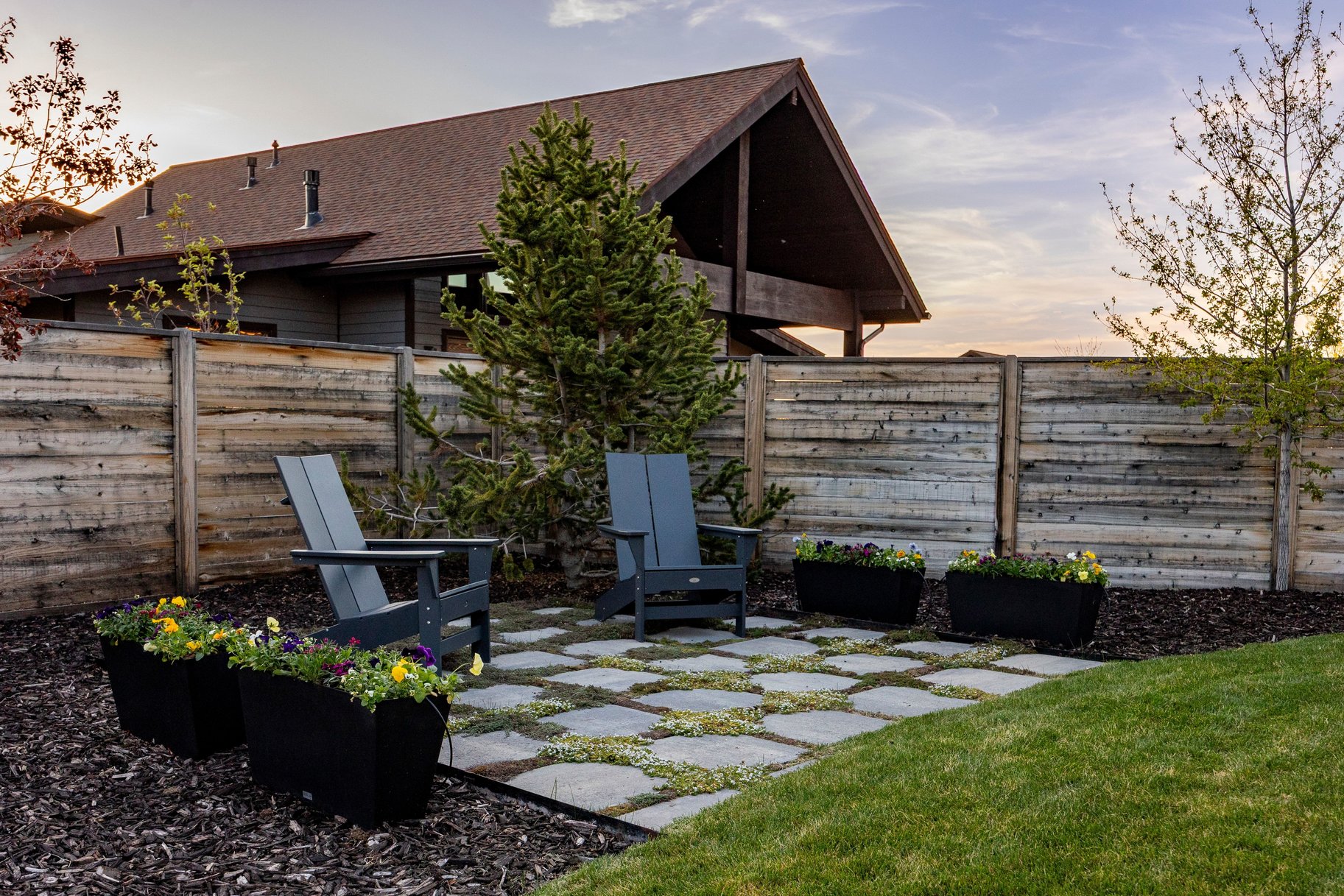 Outdoor patio area featuring square paver stones with interspersed ground cover
