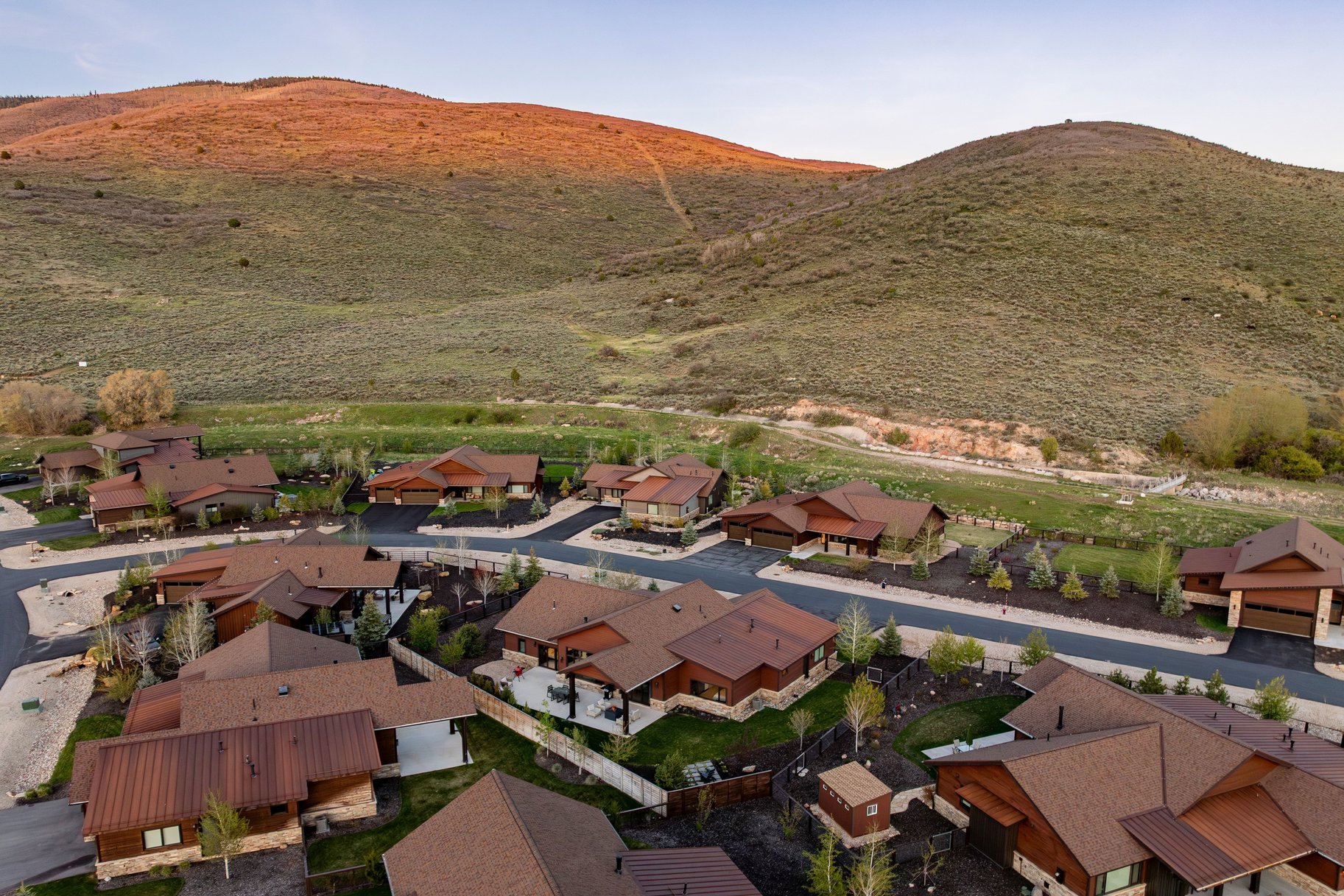 Residential community featuring multiple properties with brown roofs and natural wood or stone exteriors