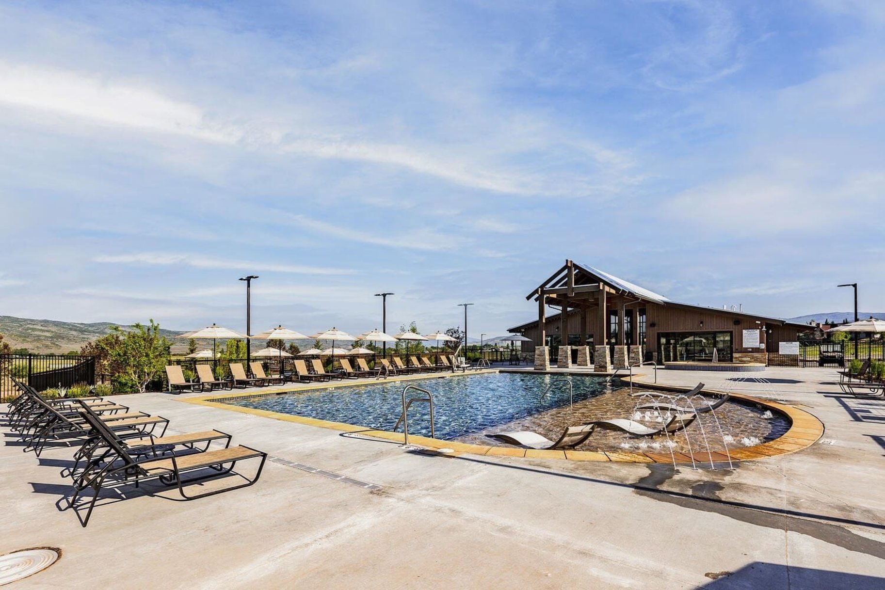 Outdoor swimming pool with integrated lounge seating and water features