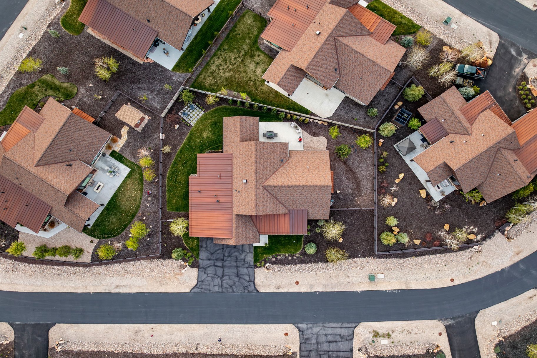 Aerial perspective showcasing a residential property with a brown shingle roof and a private driveway