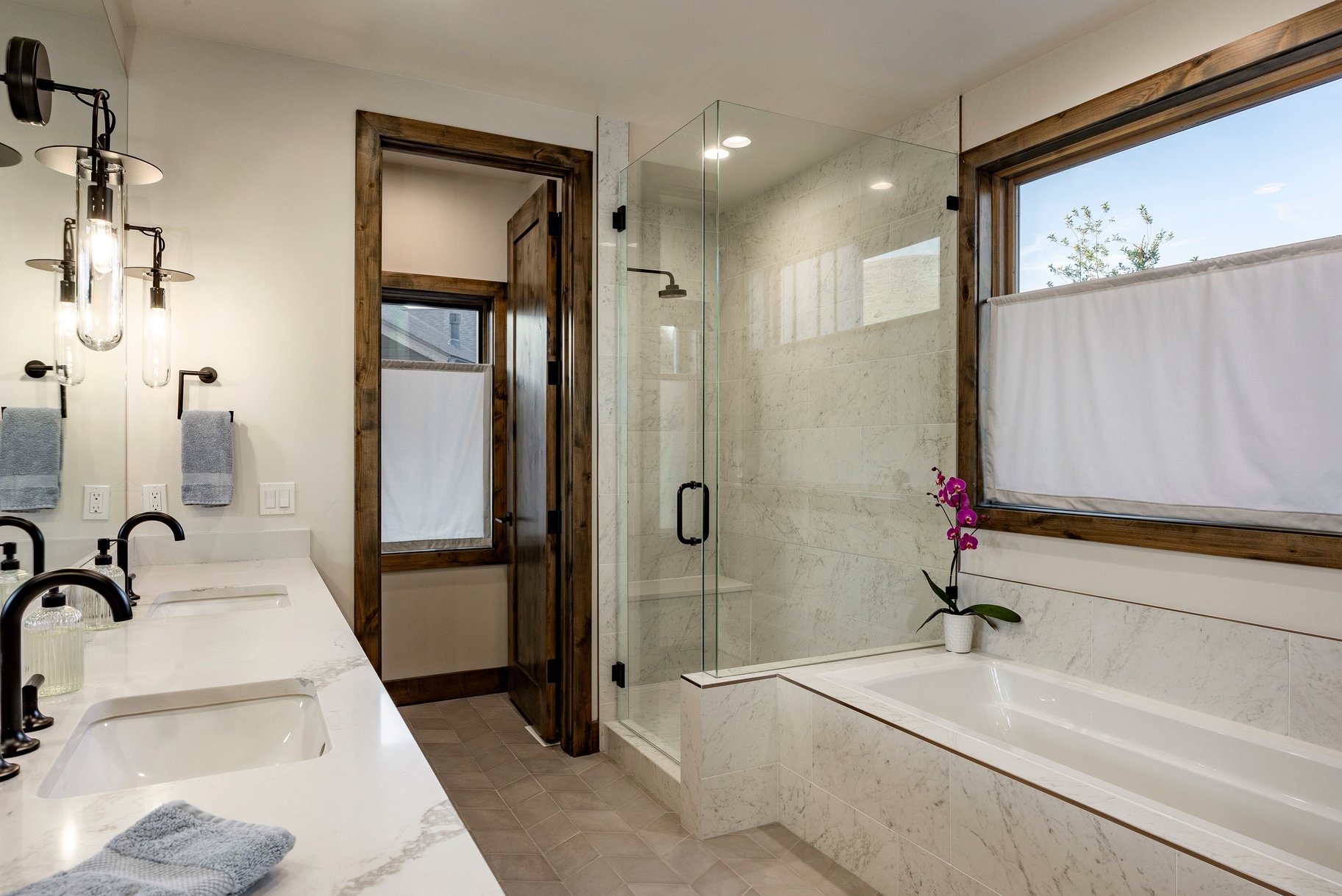 Bathroom featuring a dual vanity with undermount sinks and matte black fixtures