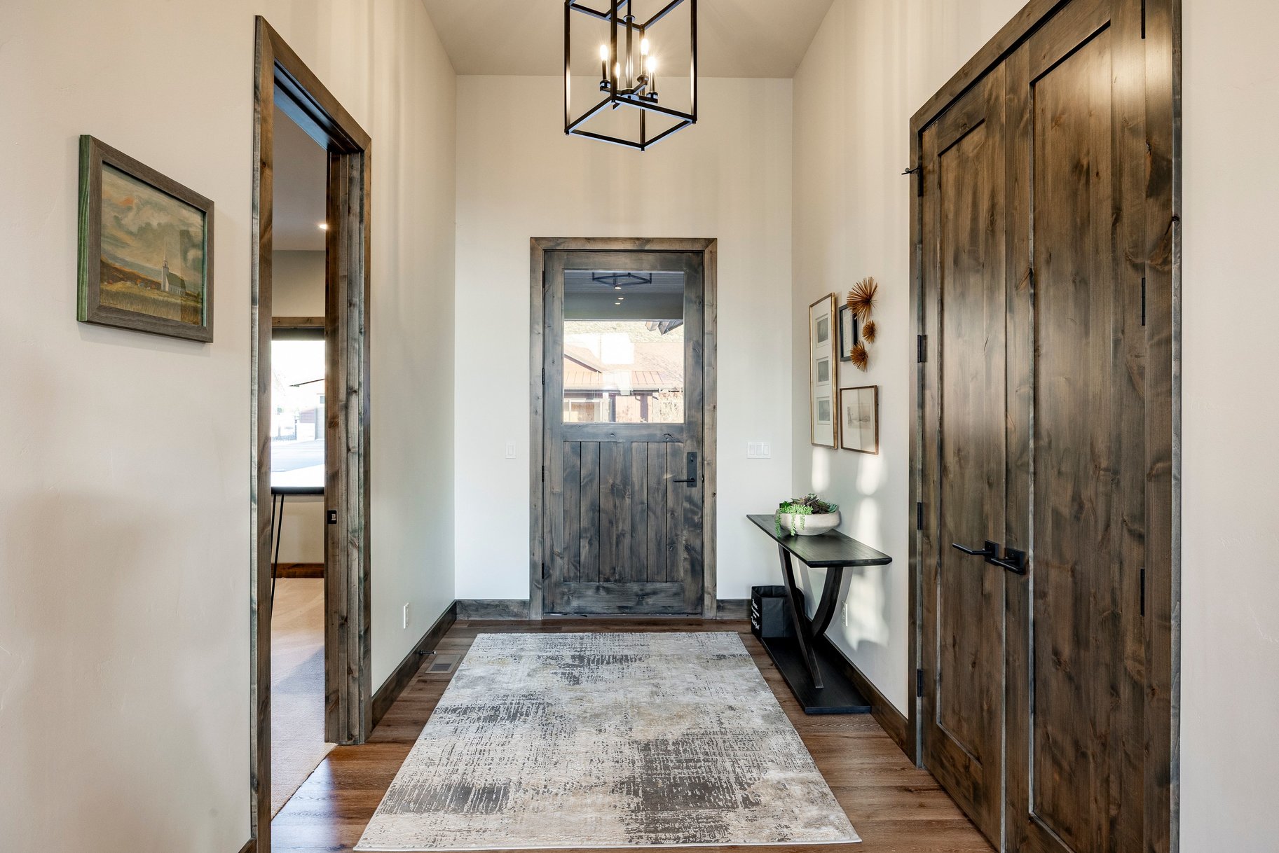 Entryway featuring distressed wood-finish doors, matching trim, and wood-finish flooring