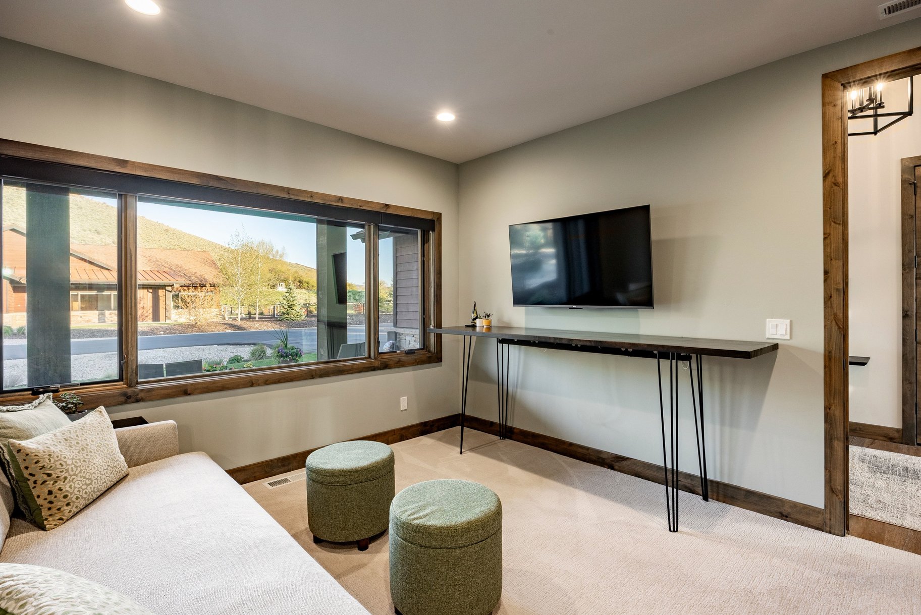 Spacious room featuring a large wood-framed window, recessed lighting, and light-toned carpeting