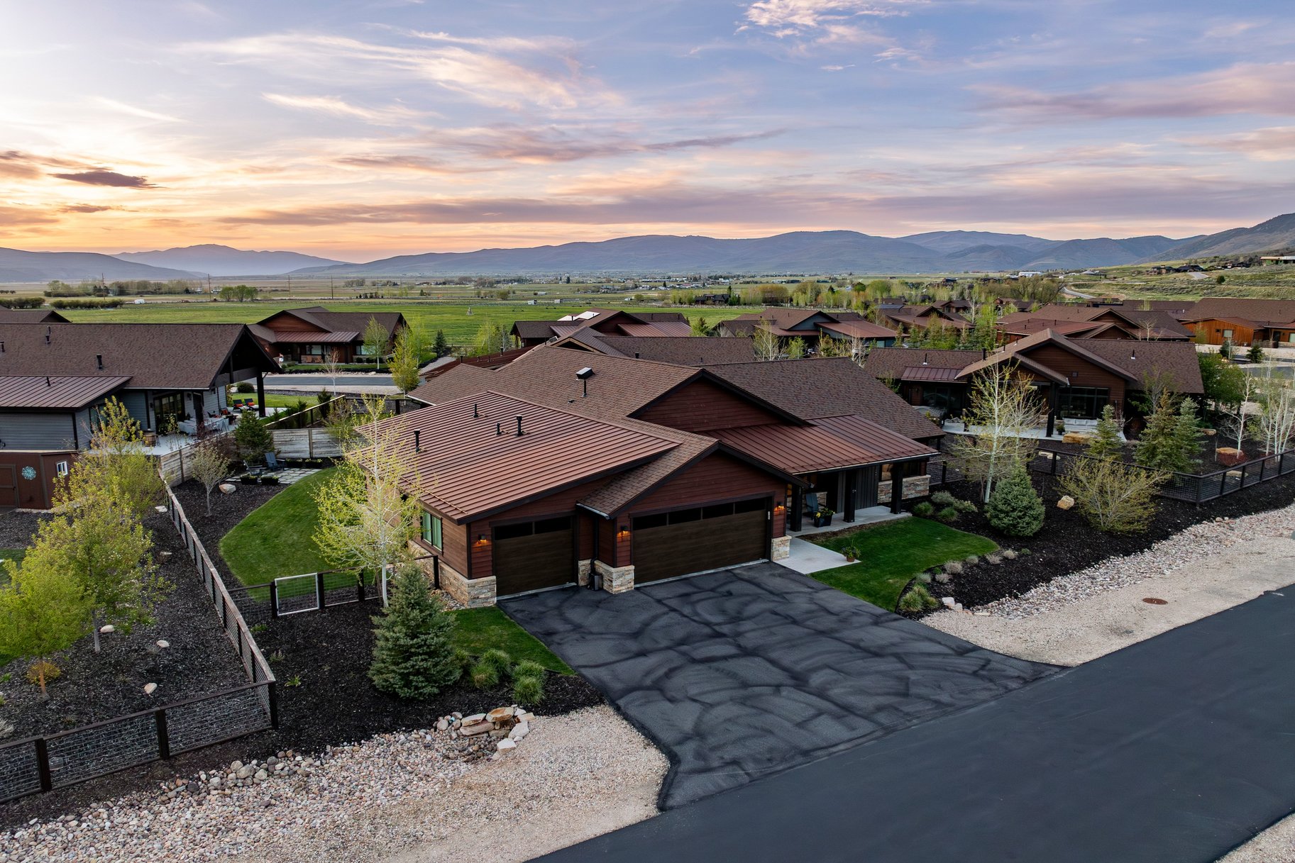 Craftsman-style residence featuring a dark metal roof, natural wood siding, and stone accents
