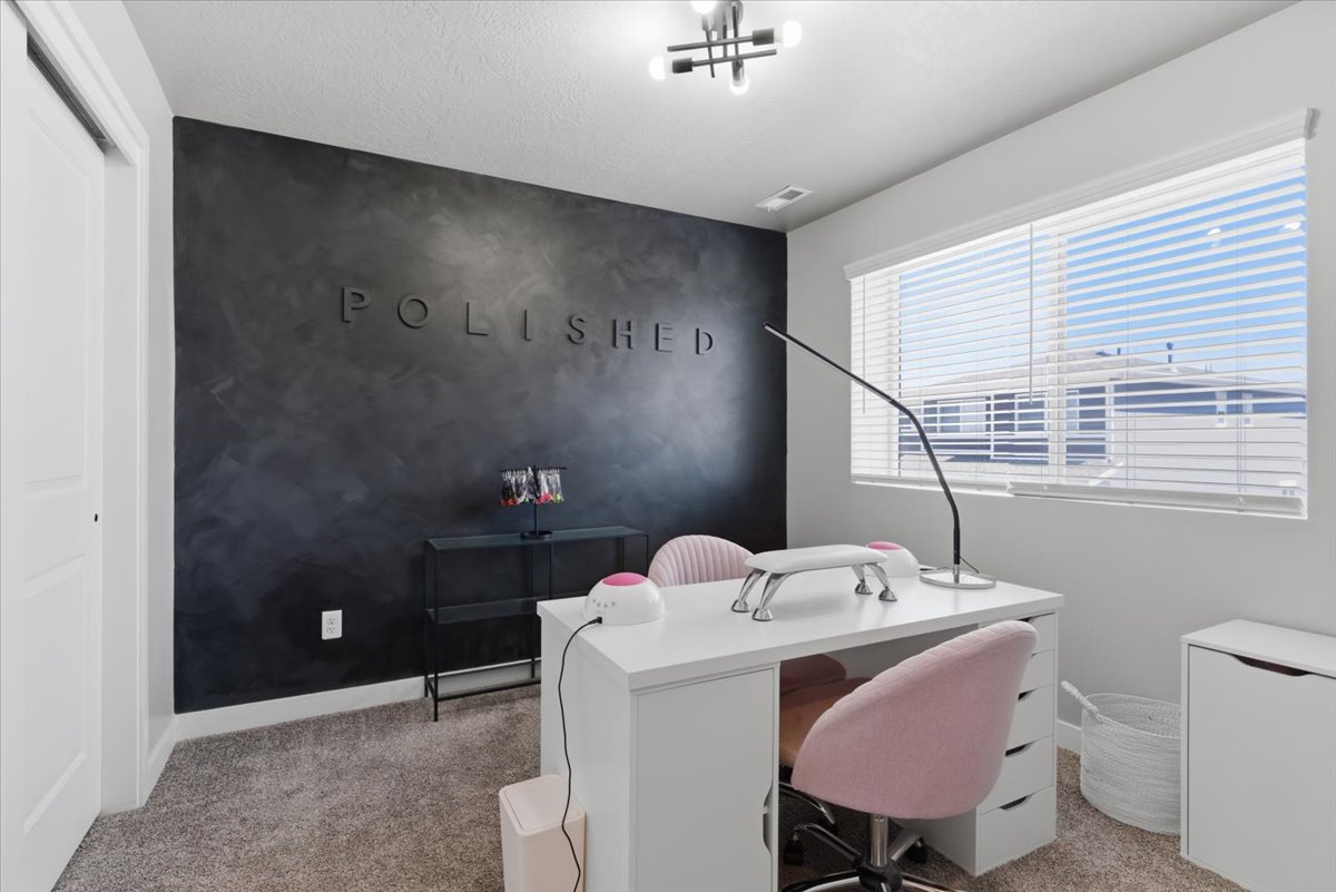 Room featuring a dark accent wall with textured finish, light grey carpet, and a white window with horizontal blinds