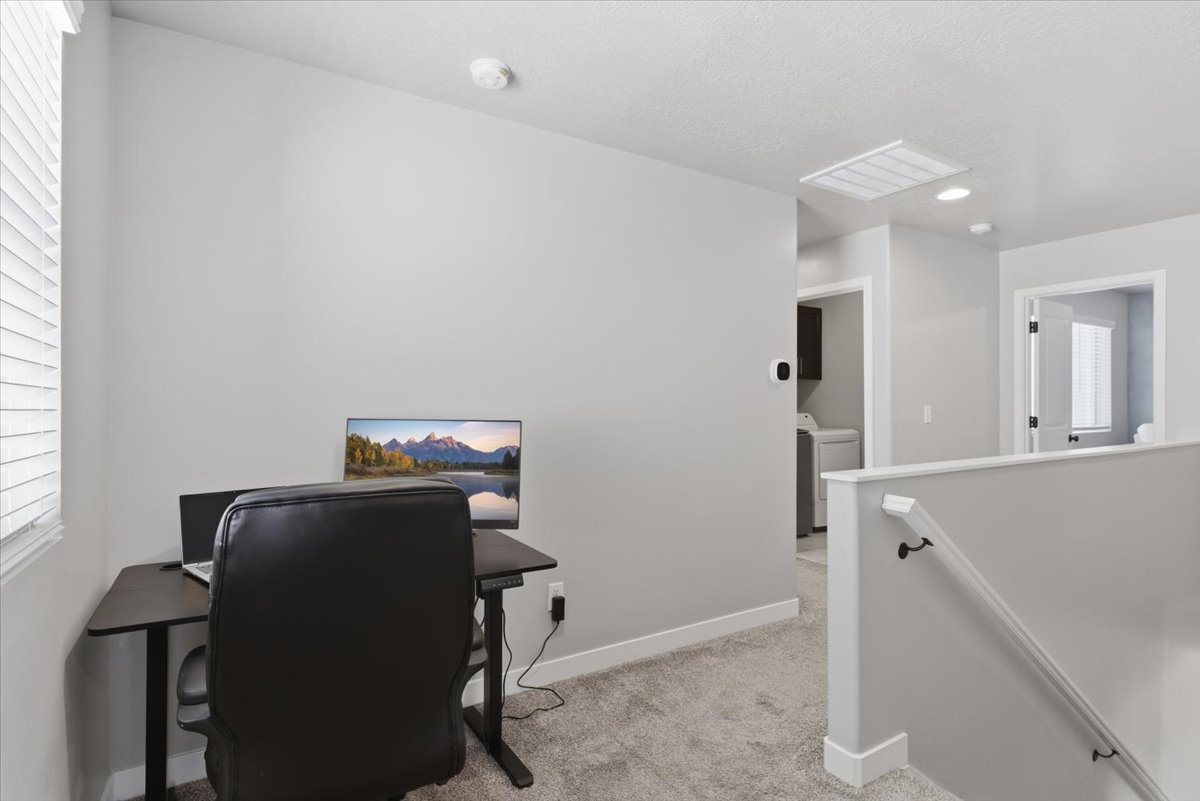 Carpeted hallway featuring light gray walls and white trim