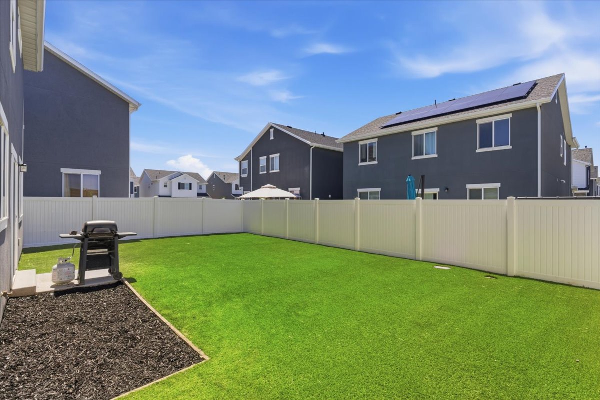Expansive green lawn with a white privacy fence