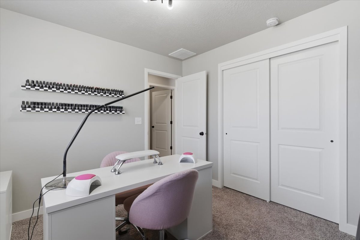 Room featuring light gray walls, textured carpeting, and white trim