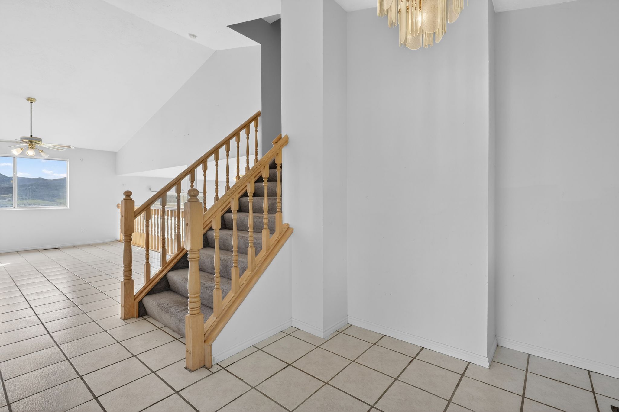 Foyer entry with tile flooring and a decorative chandelier