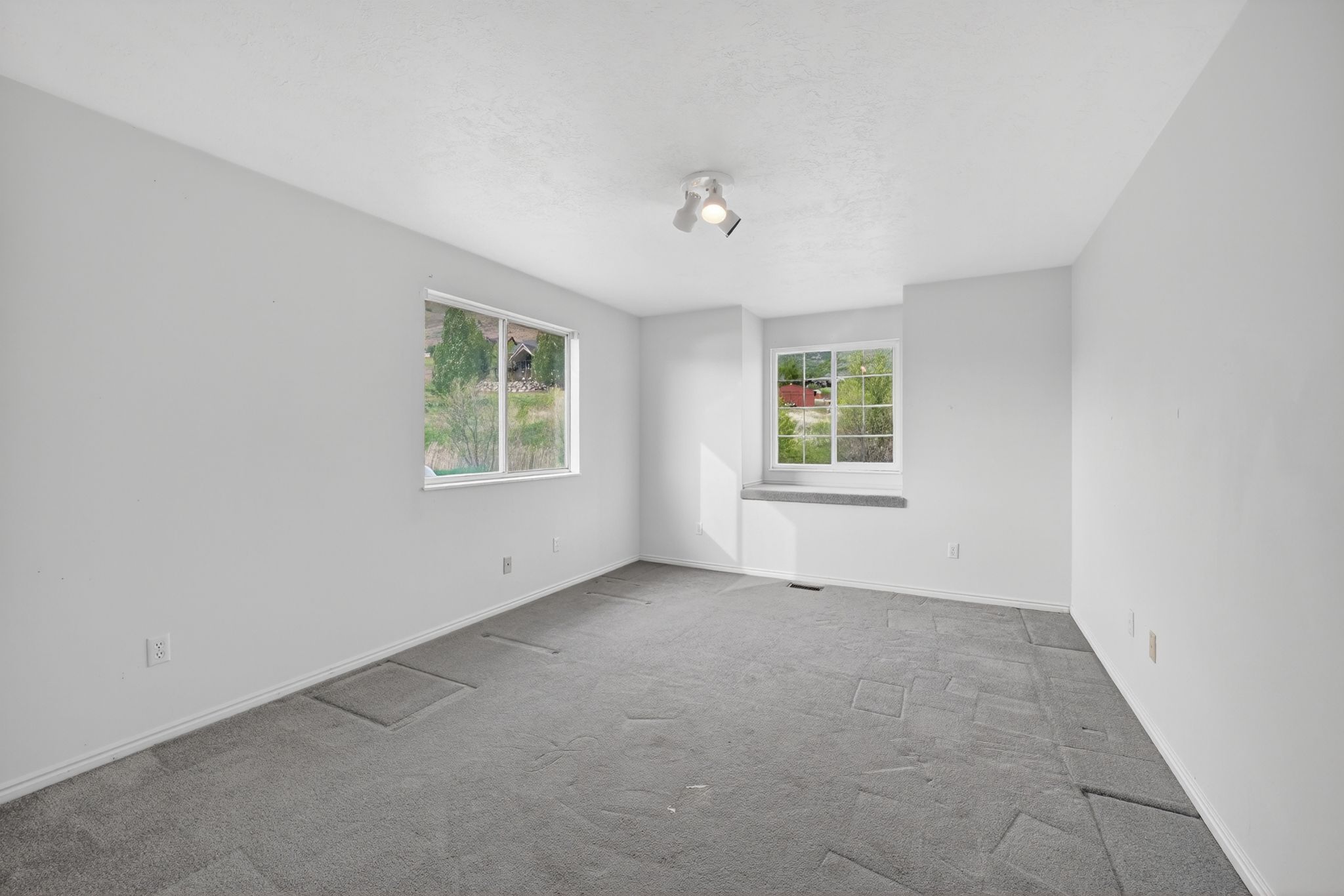 Spacious interior room with light gray carpet and white walls