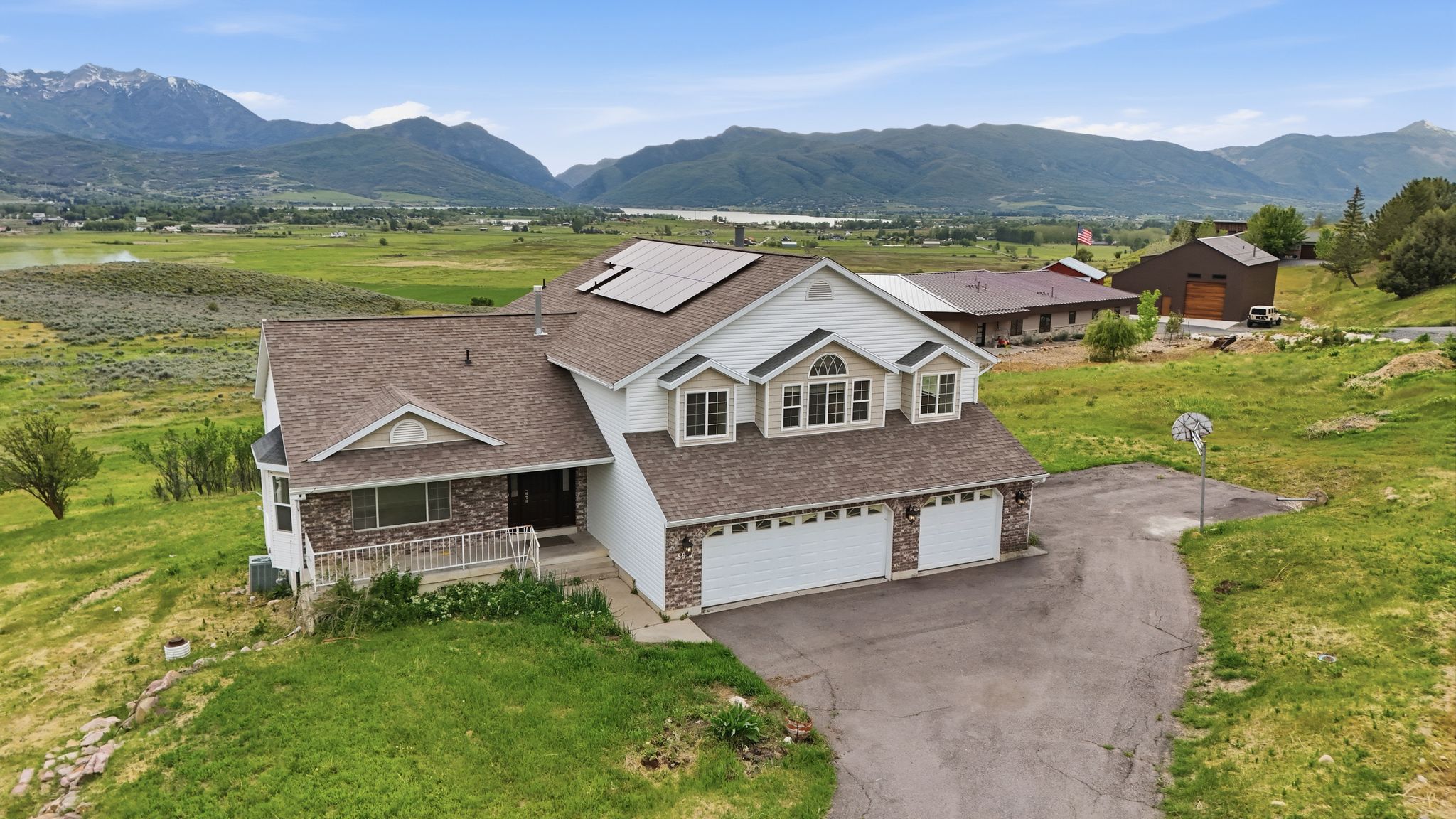 Exterior showcasing a multi-car garage, solar panels, and a stone and siding facade