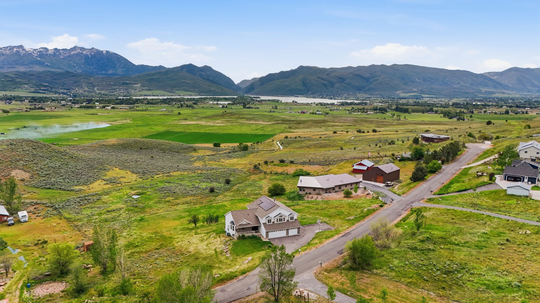 Aerial perspective showcasing expansive green landscapes, distant mountain ranges, and bodies of water