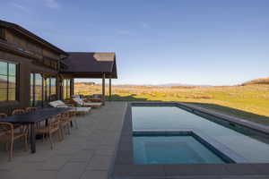 Expansive outdoor patio with a built-in swimming pool and integrated spa