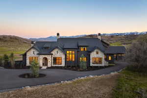 Stone and dark-paneled exterior with multiple gables and a multi-car garage
