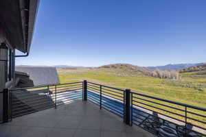 Expansive outdoor patio featuring tile flooring and a modern horizontal bar railing