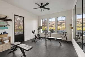 Dedicated fitness space featuring impact-absorbing flooring and a black ceiling fan with integrated lighting
