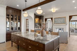 Central kitchen island with a marble countertop and rich wood-finish cabinetry