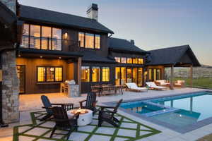 Outdoor living area featuring a swimming pool, integrated spa, and spacious patio