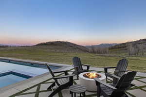 Outdoor patio featuring a built-in fire pit, swimming pool, and integrated spa