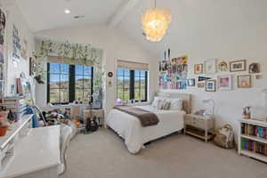 Vaulted ceiling with a contemporary chandelier, carpeted flooring, and a built-in window seat
