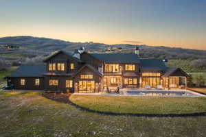 Expansive rear exterior featuring a dark vertical siding and stone facade