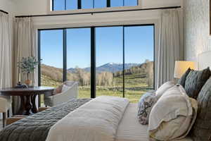 Expansive floor-to-ceiling windows with black frames, showcasing mountain and valley scenery