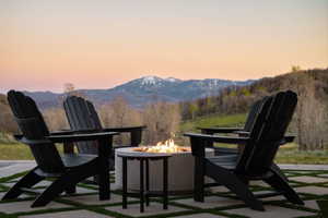 Outdoor patio featuring a built-in fire pit and mountain scenery