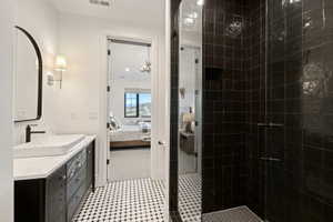 Bathroom featuring a vanity with a rectangular vessel sink, matte black faucet, and a black framed arched mirror