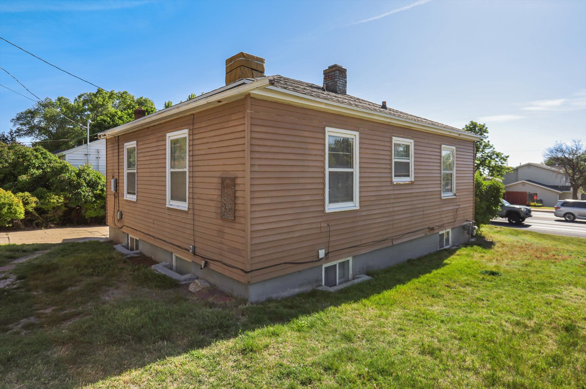 Single-story residence featuring horizontal plank siding and multiple windows