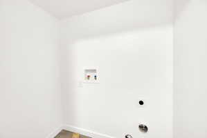 Dedicated utility space featuring white walls and baseboards