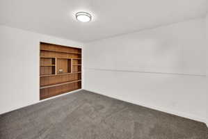 Built-in wood shelving with varied compartment sizes, recessed into a white wall