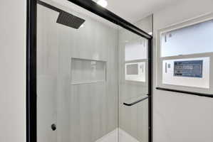 Modern walk-in shower featuring a matte black framed glass enclosure