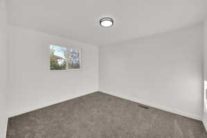 Room featuring plush gray carpeting, white painted walls, and white trim