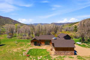 Expansive property featuring a multi-structure residence with wood siding and stone accents