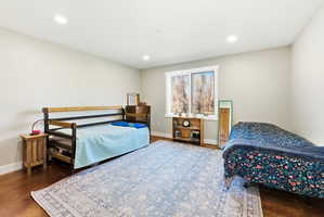 Spacious room with recessed lighting, light-toned walls, and wood-finish flooring