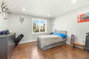 Spacious room featuring rich, warm-toned flooring and white baseboards